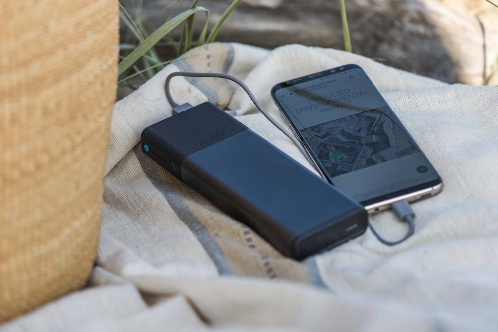 Nimble portable charger on a blanket charging an iPhone designed by Swagger