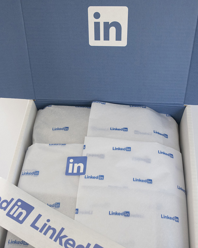 Custom branded curbside recyclable box for LinkedIn with custom branded tissue paper and custom branded paper tape designed and produced by Swagger.