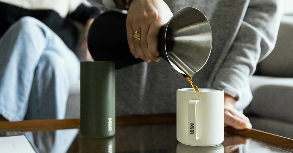 Coffee being poured into a white custom branded MiiR mug