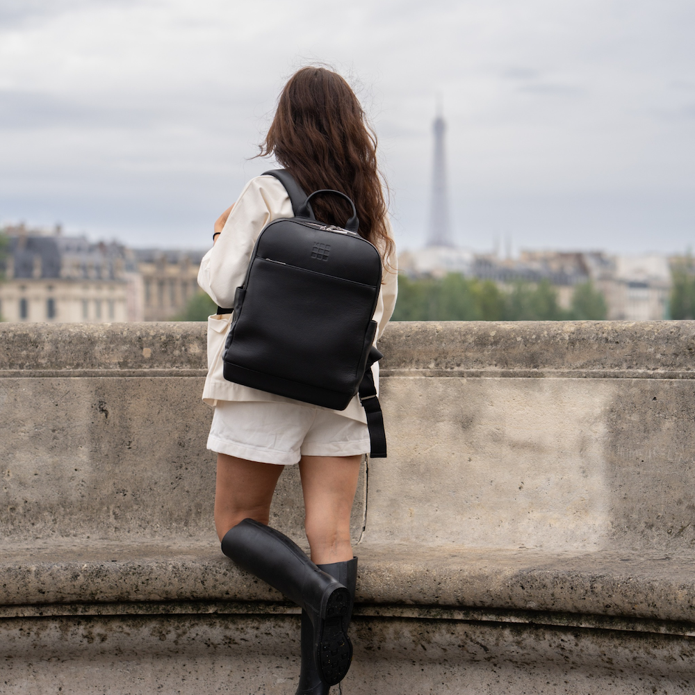 Woman wearing the Moleskine® Classic Pro Backpack standing in front of the Eiffel Tower curated by Swagger.