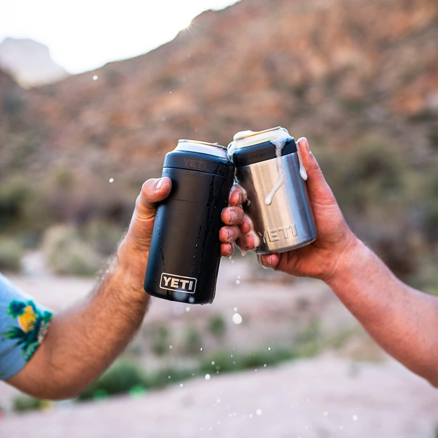 Two people clinking two YETI Rambler 12oz Colster Can Holder filled with a beverage designed by Swagger.