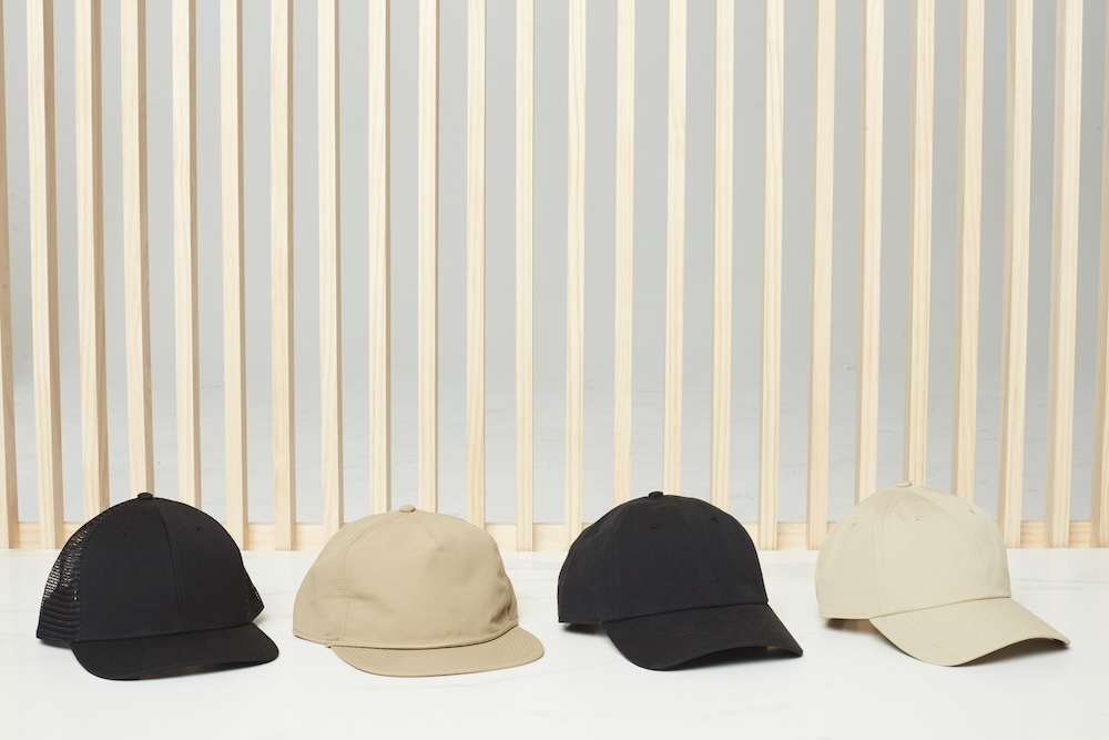 Tan and black Known Supply baseball caps can be designed and curated by Swagger 