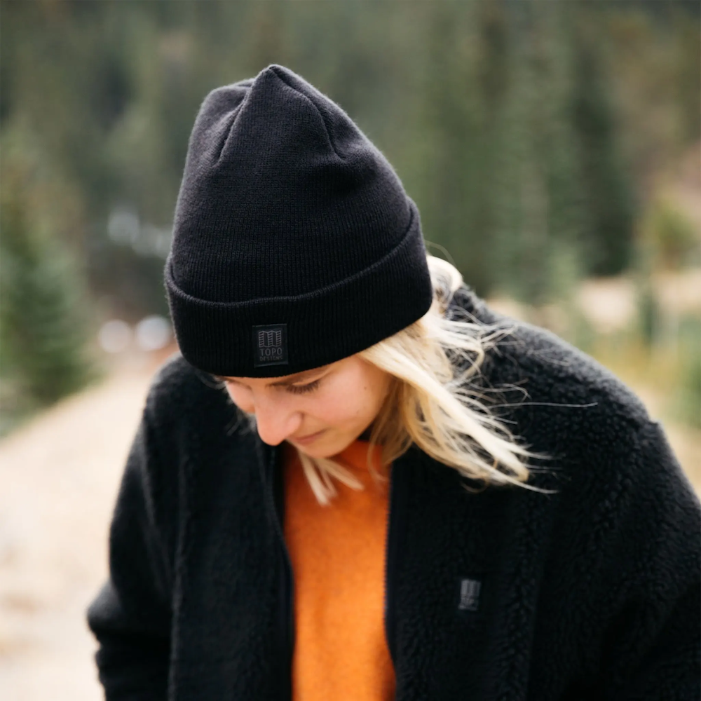 A woman wearing Topo Designs Work Cap beanie, customized by Swagger.
