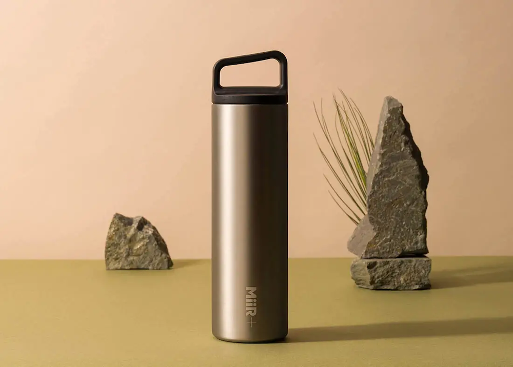 A MiiR narrow mouth water bottle in front of rock statues. Bottle can be custom branded by Swagger