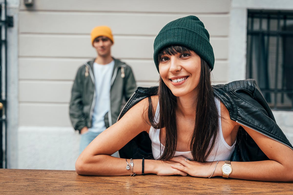 A man and woman wearing Atlantis beanies can be custom branded by Swagger