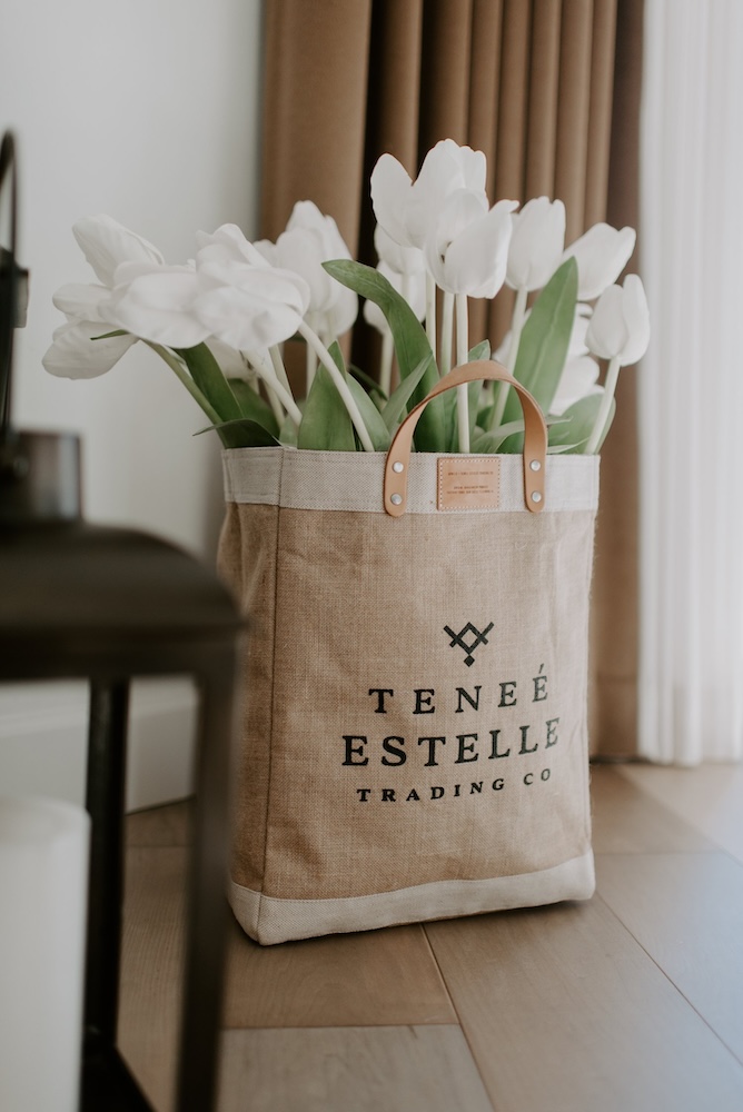 Apolis bag photographed with tulips on a wood floor curated by Swagger.