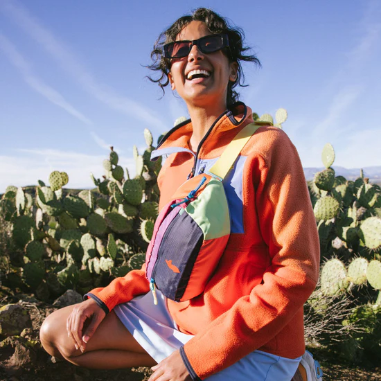 Woman smiling while wearing the Cotopaxi Bataan Hip pack curated by Swagger.