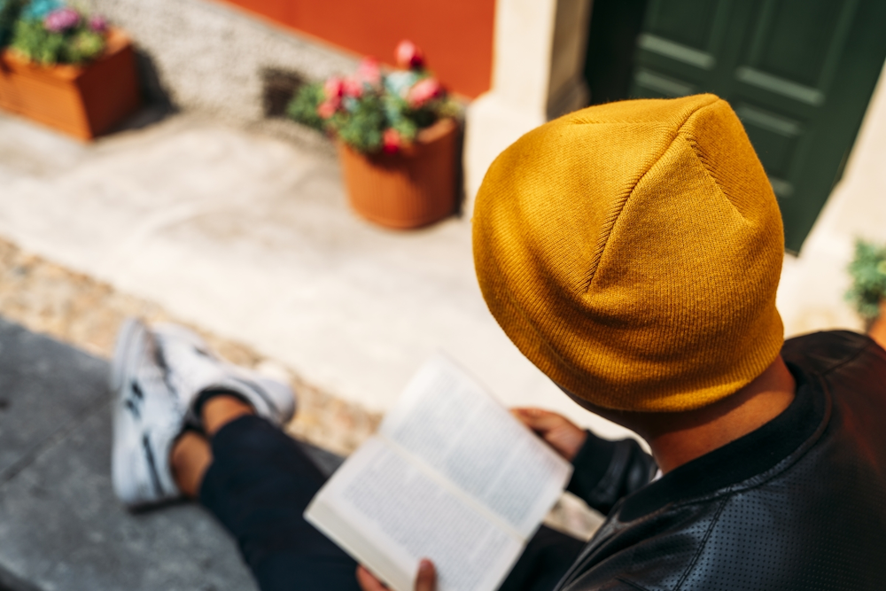 Man reading while wearing an Atlantis yellow beanie custom branded by Swagger