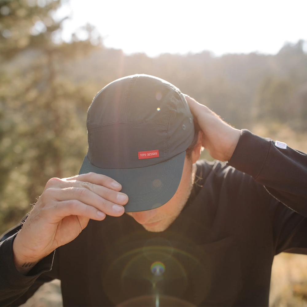 A man wearing a Topo Designs Camp Hat, ready to be customized with your brand's logo, curated by Swagger.