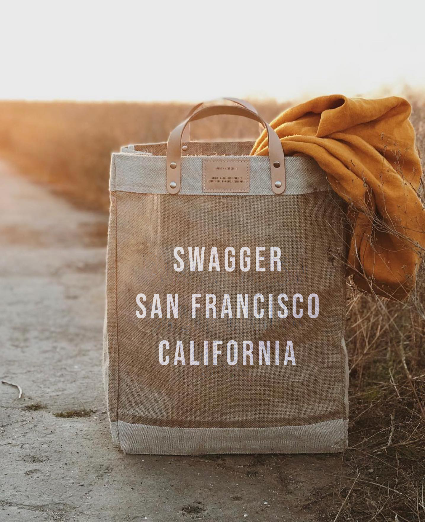 Apolis Market Bag being shown with picnic blanket sticking out, and “Swagger San Francisco California” printed on the bag. Curated by Swagger.