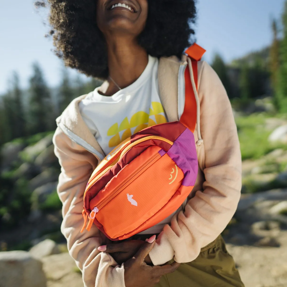 Woman wears the Cotopaxi Del Dia Hip Pack designed by Swagger.