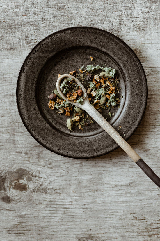 Image of Aesthete Tea’s Herbal Blend Samhain loose leaf with traditional plate and tea spoon.