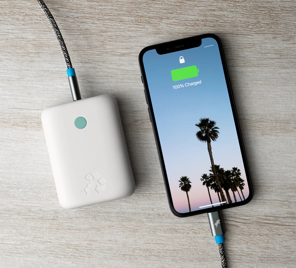 Nimble portable charger curated by Swagger. Shown connected to an iPhone via usb-c that is charging.